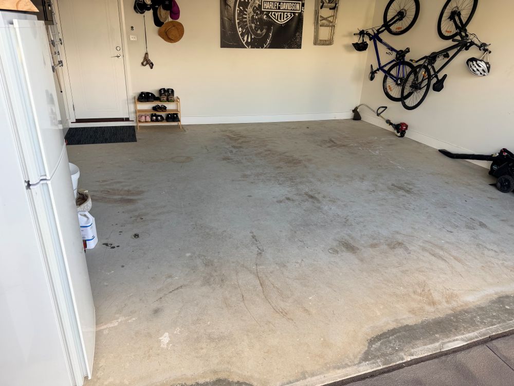 Evo Epoxy grinding a garage slab with dust extraction before coating