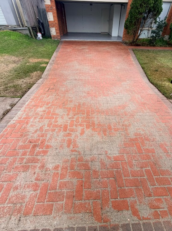 Driveway before grinding and sealing, original red finish