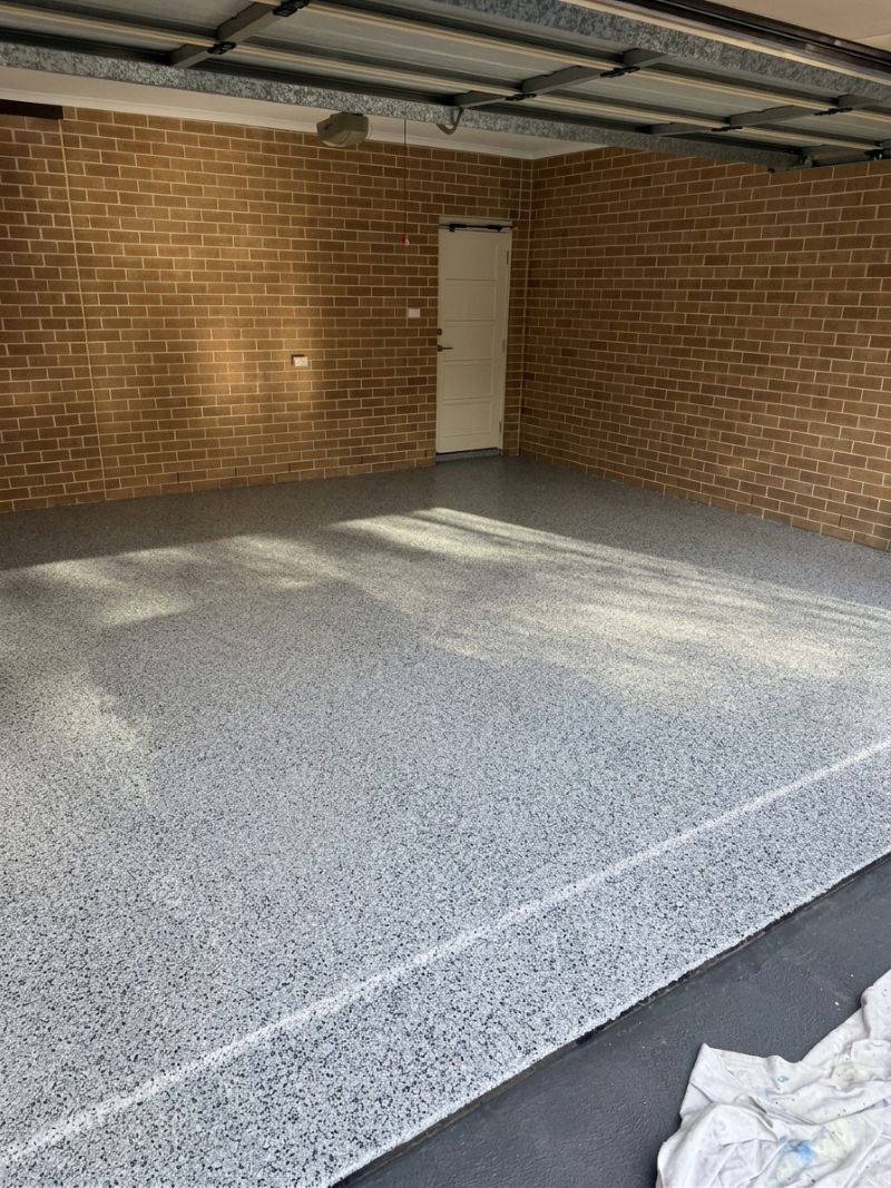 The same garage after coating, finished in a grey flake epoxy floor